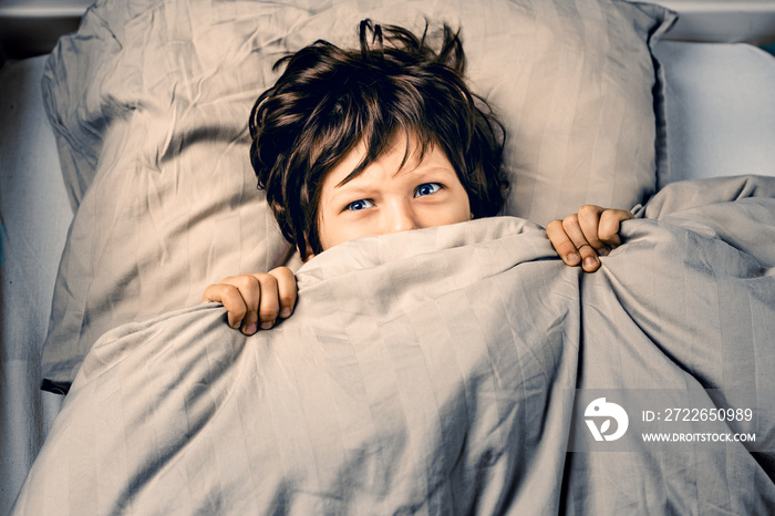 Little boy covering his face scared of nightmares