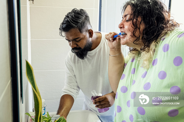 Couple brushing their teeth in the bathroom in the morning