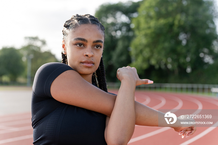 Female athlete stretching arms before training