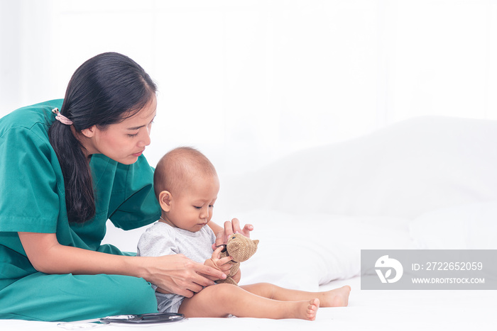 Pediatrician doctor prepare for examines baby girl with stethoscope checking heart beat.