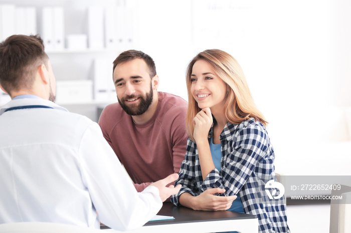 Doctor consulting young couple in clinic