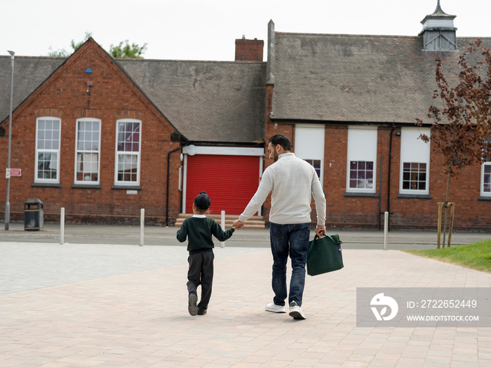 Father walking son (6-7) to school