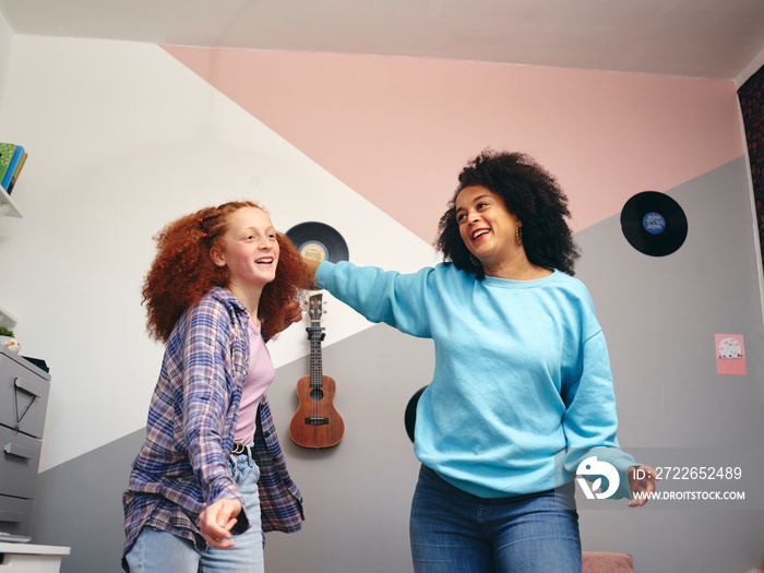 Mother and daughter  dancing in room