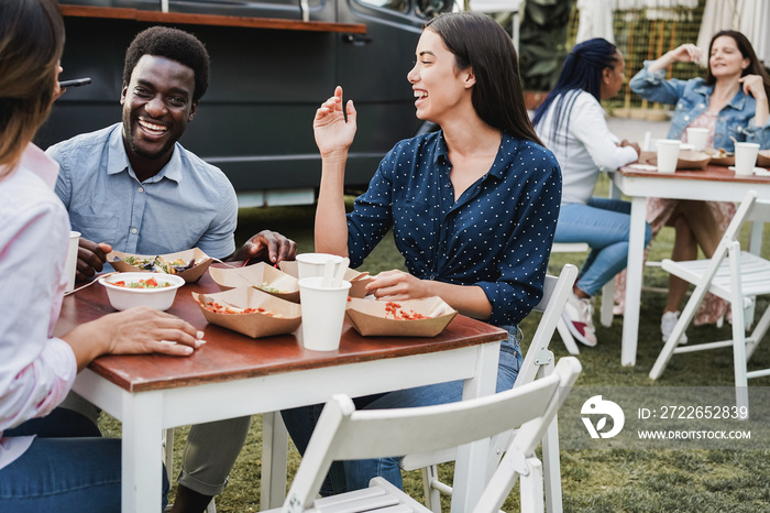 Multiracial people eating at food truck restaurant outdoor - Focus on african man face