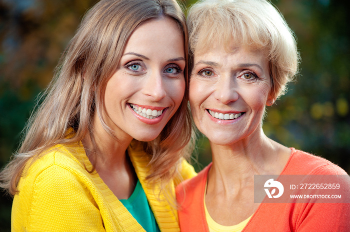 Mother with her daughter looking at the camera outdoor