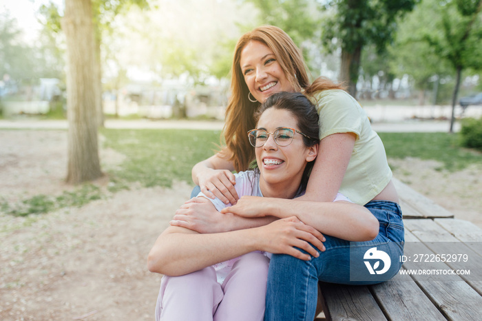 Two happy girlfriends hugging in the park. Two best friends females. Women sorority