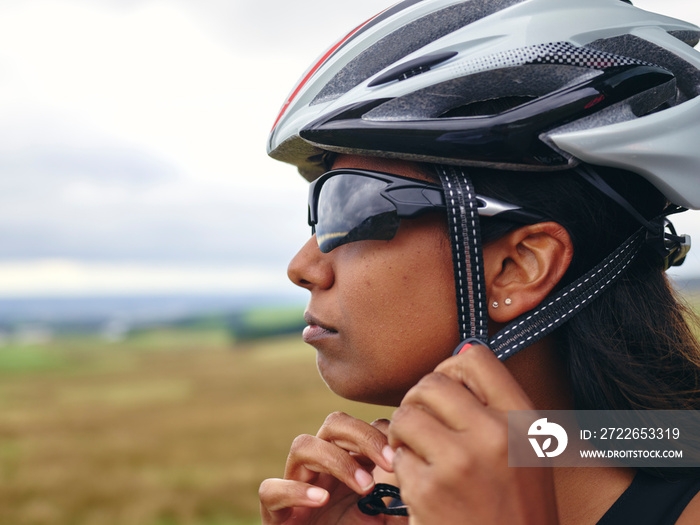 Woman putting on bicycle helmet