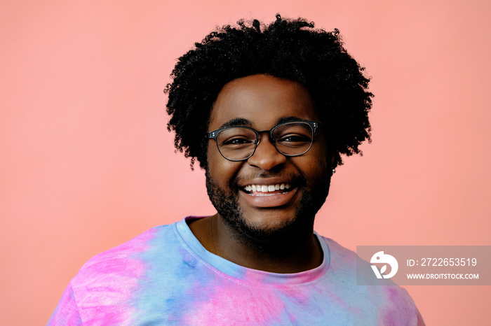 young happy african american man posing in the studio over pink background