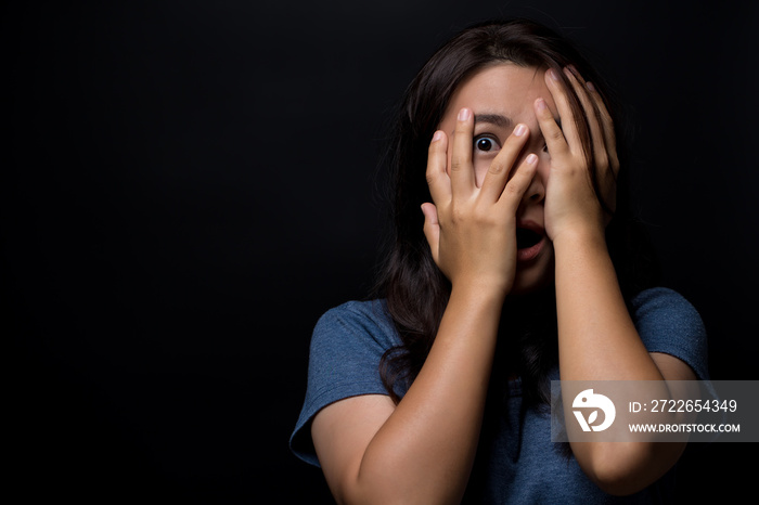 Scared woman on isolated black background