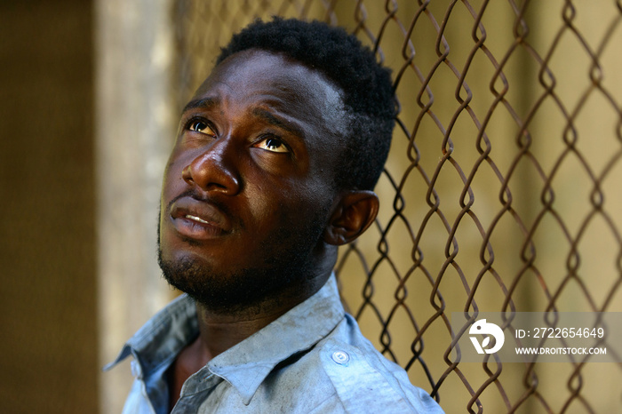 Face of young homeless African man looking up in the streets