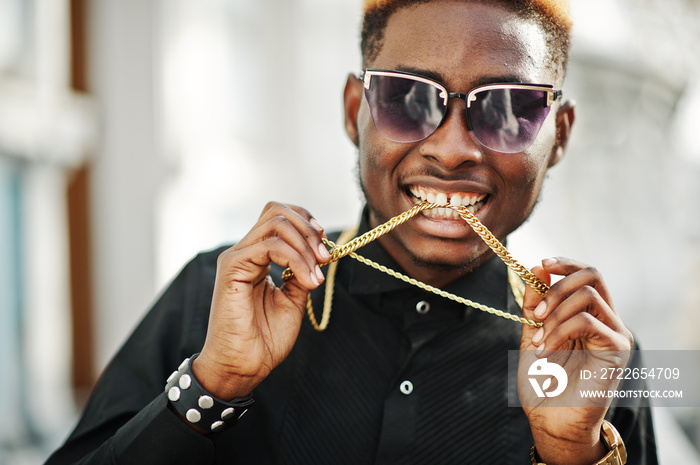 Chic handsome african american man in black shirt with gold chain and sunglasses.