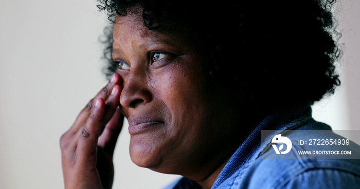 Sad black woman wiping tears in desperation. Person crying