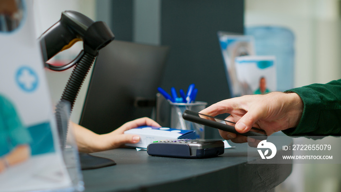 Elderly person paying medicaments and drugs with telephone and nfc, making payment at pharmacy counter to buy prescription treatment. Using mobile phone to pay vitamins. Close up. Tripod shot.