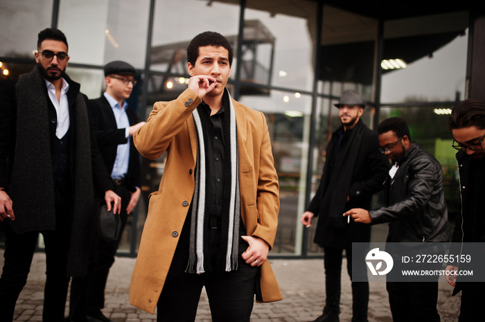 Group of handsome retro well-dressed man gangsters smoking outdoor. Multiethnic male bachelor mafia party.