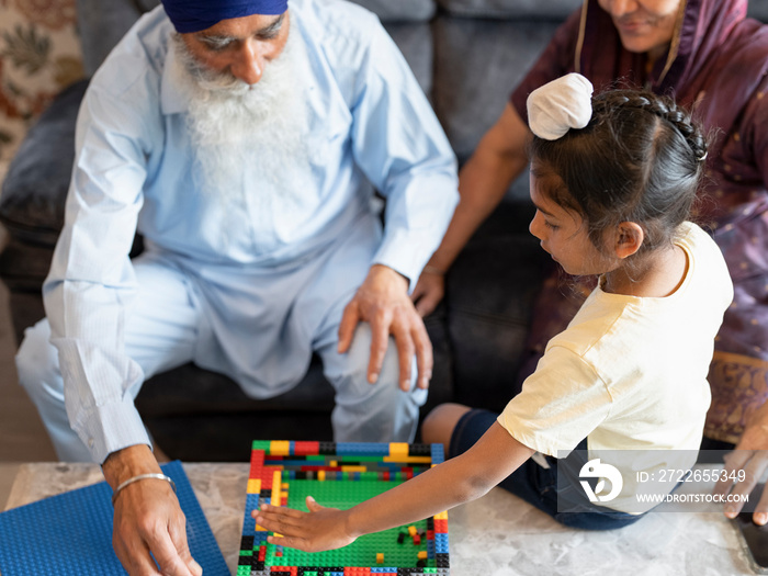 Grandparents and grandson (6-7) playing with toy blocks