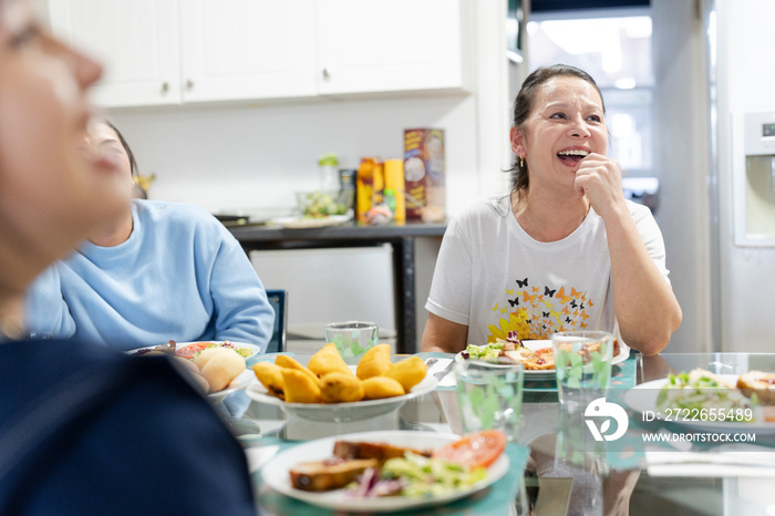 Family sitting at dining table and enjoying lunch