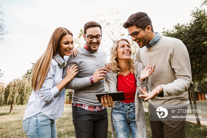 Group of friends in the park hanging out on social networks