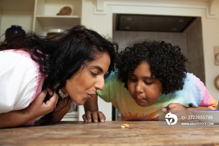 Mid-sized mother and son playing in the kitchen