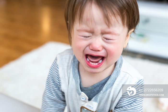 Upset toddler boy screaming and crying in his house