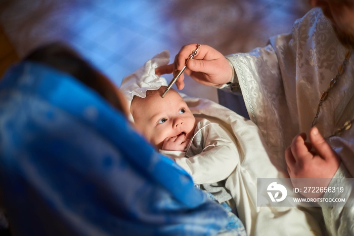 A small child at a baby christening ceremony in a church. .Baptism of the newborn. The sacrament of baptism. Child and God