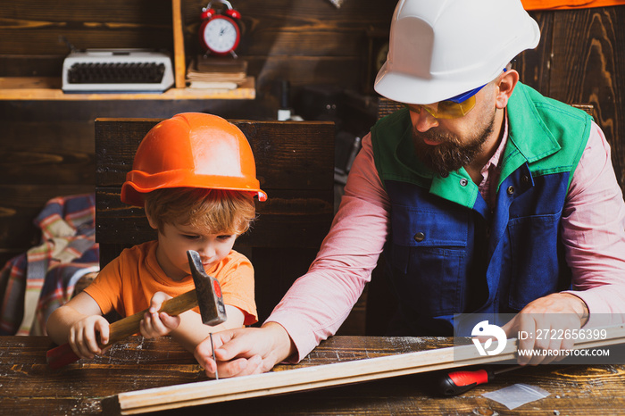 Father and son working with a hammer. Future kids profession. Construction of dad and boy in the garage.