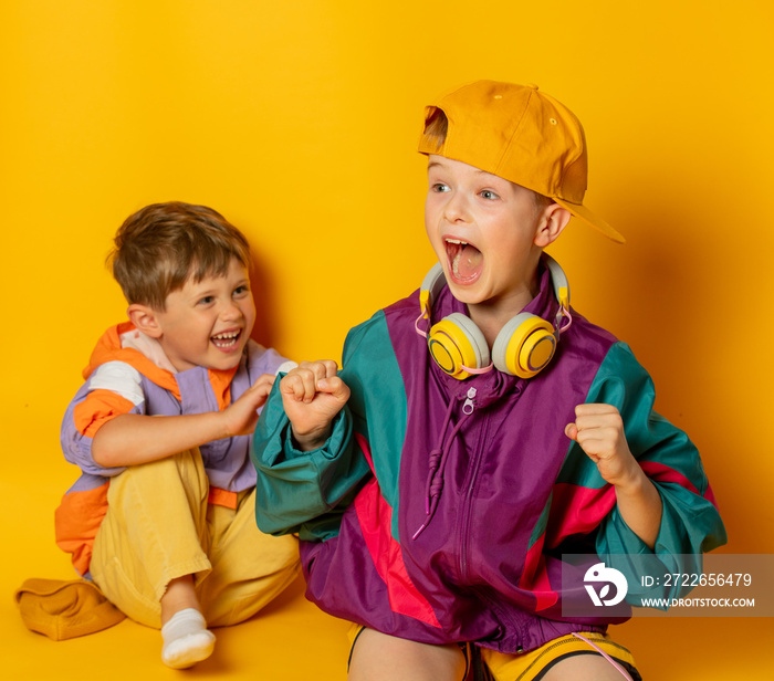 Two kids in stylish vintage 80s clothes have a fun on yellow background