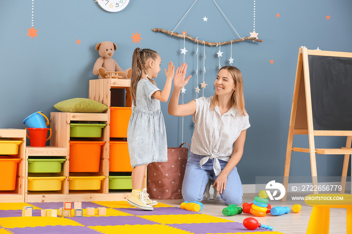 Nanny and cute little girl playing at home