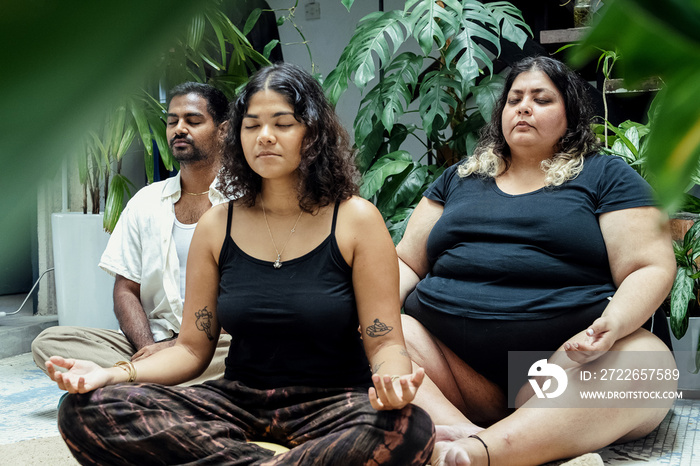 Friends meditating together at home