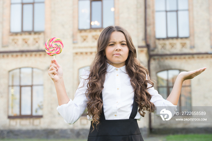 School nutrition. Sugar diet. Sweet joy. Happy kid with sweet candy. Happy childhood. Kid child holding lollipop candy. Sweets concept. Happy kid with candy outdoors having fun. Schoolgirl relaxing