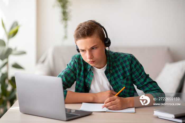 Concentrated school boy studying online from home