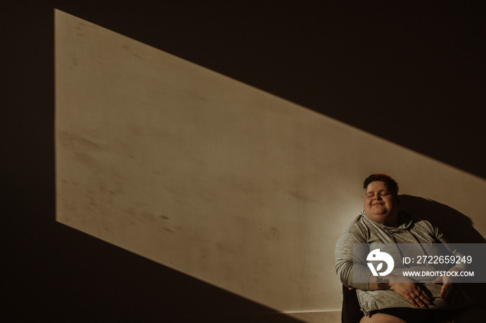 portrait of a plus size woman sitting in the sun smiling