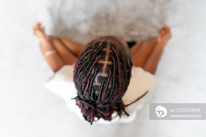 Directly above view of young woman practicing yoga at home