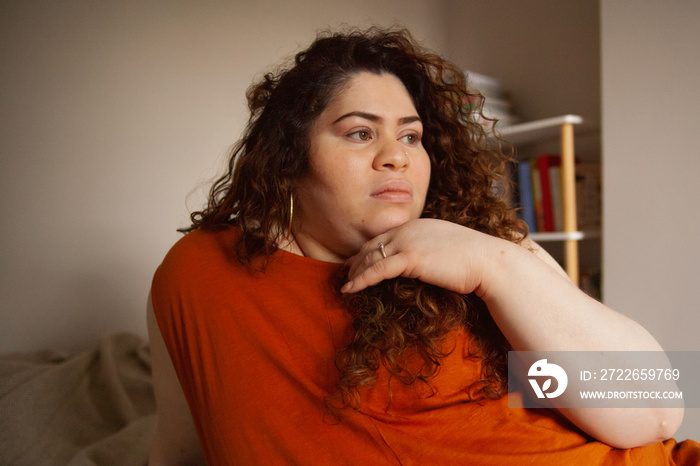 Plus-sized Sri Lankan woman with vitiligos sitting on her bed