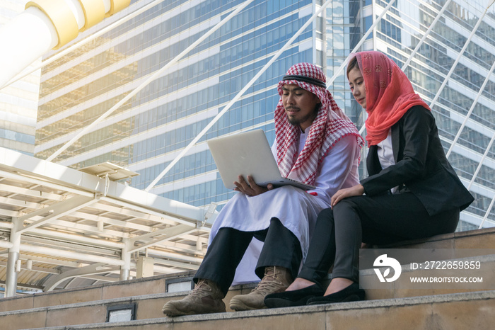 Arab Businessman and Businesswoman using computer, finance concept