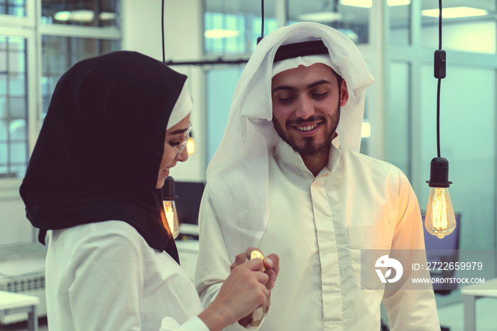 Young arabian muslim woman in hijab black clothes hold in hand holding bitcoin. Cryptocurrency exchange