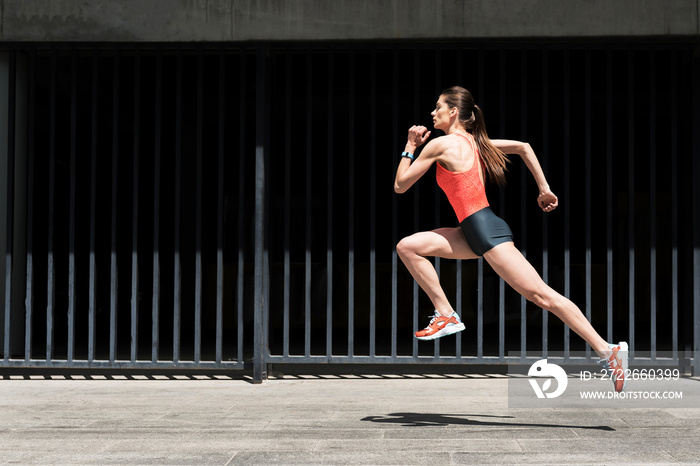 Confident young woman running outdoors