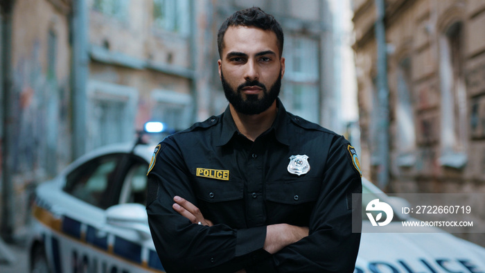 Portrait serious young man cops hold pistol stand near patrol car look at camera enforcement officer police uniform auto safety security communication control policeman portrait close up slow motion