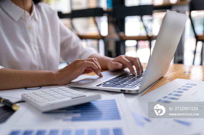 Businesswoman uses a laptop for a marketing project while analyzing company turnover using a laptop computer. An accountant working in an office initiates a planning management collaboration.