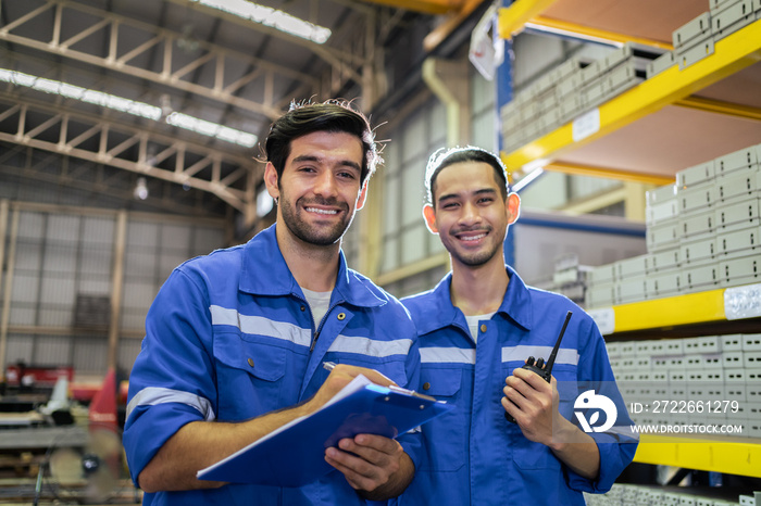 Portrait of two male industrial worker working in manufacturing plant.