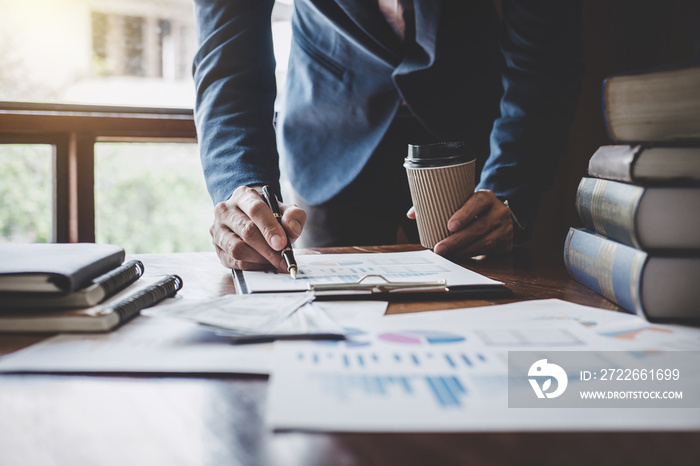 Businessman pointing at graph and chart to analysis use for plans to improve quality, business finances and accounting concept