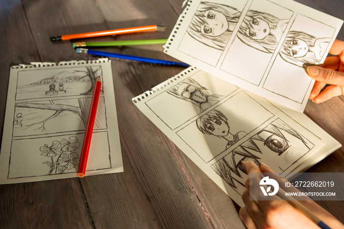 Artist drawing an anime comic book in a studio. Wooden desk, natural light