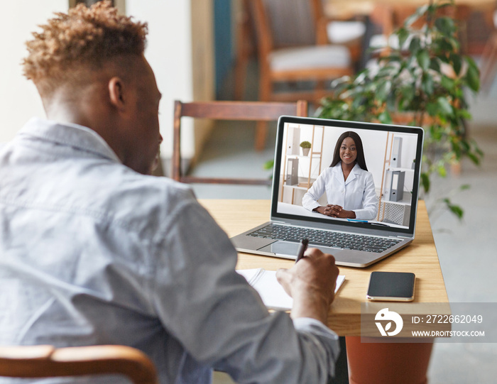 Appointment with doctor online. Black guy having video chat with therapist, receiving professional medical help remotely