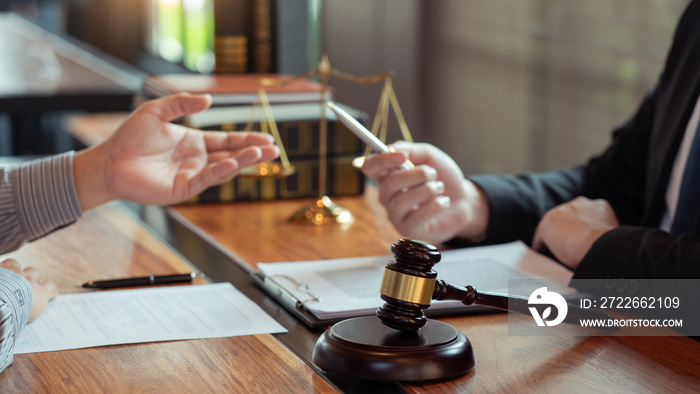 Lawyer working with client discussing contract papers with brass scale about legal legislation in courtroom, consulting to help their customer.