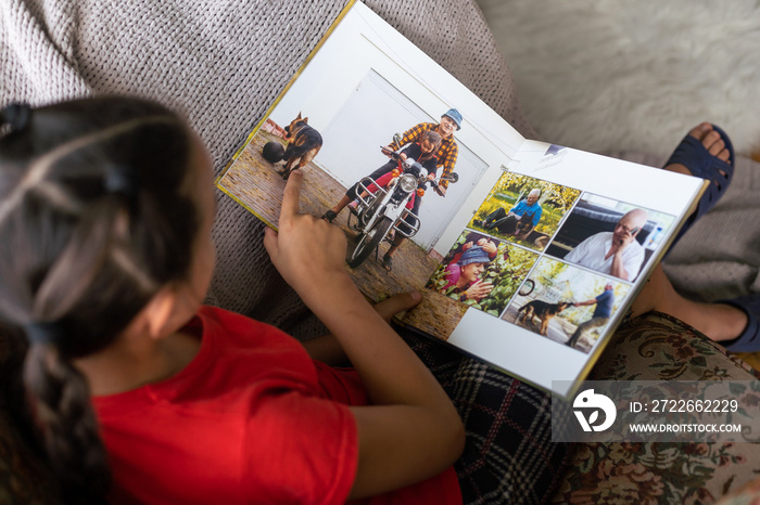 Little girl looking photobook at home. Close up shot. Family, childhood and leisure concept