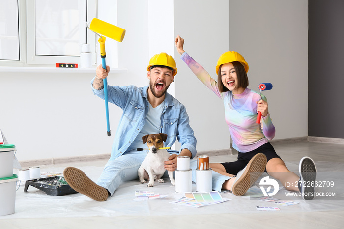 Happy young couple with cute dog resting during repair in their new house