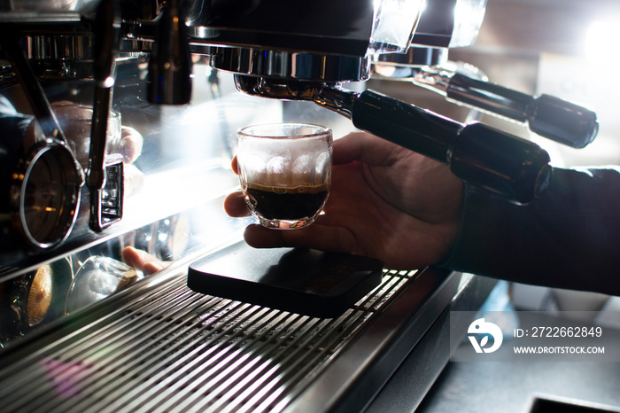 coffee machine makes double espresso in glasses at night, the process of making coffee, close-up