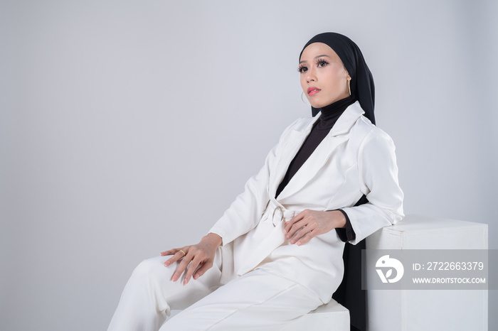 Portrait of a beautiful female model wearing hijab, a lifestyle apparel for Muslim women isolated on grey background. Idul Fitri and hijab fashion concept.