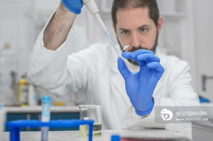 Scientist filling test tubes with pipette in laboratory