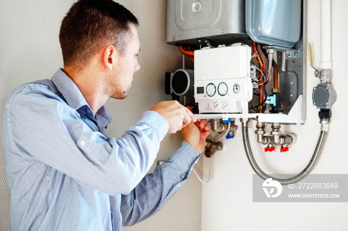 Plumber attaches Trying To Fix the Problem with the Residential Heating Equipment. Repair of a gas boiler