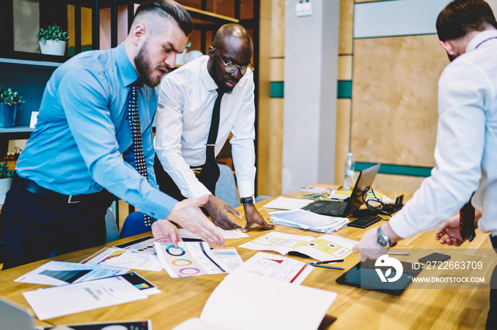 Dissatisfied proud ceo discussing problem of business project with experienced diverse office employees during brainstorming. Group of entrepreneurs collaborating on managing financial project in team